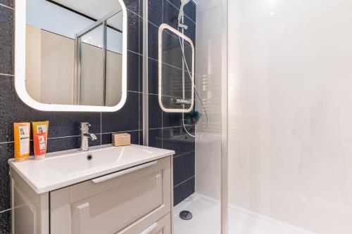 une salle de bain avec un lavabo et une douche dans l'établissement COSY APPARTMENT IN THE HEART OF PARIS, à Paris