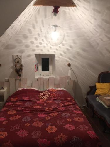 une chambre avec un lit avec une couette rouge dans l'établissement Charmante maison de pêcheur bord de mer, à Plougasnou