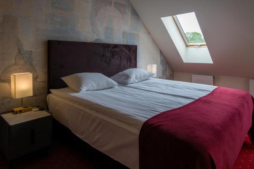 a bedroom with a large bed with a window at Agneta Apartamentai in Druskininkai
