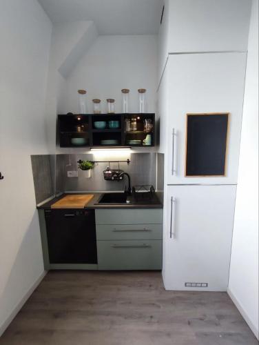 une cuisine avec un évier et un réfrigérateur dans l'établissement Confort et tranquillité près du centre-ville, à Vitré