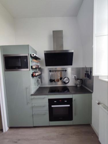 une cuisine avec une cuisinière et un réfrigérateur dans l'établissement Confort et tranquillité près du centre-ville, à Vitré