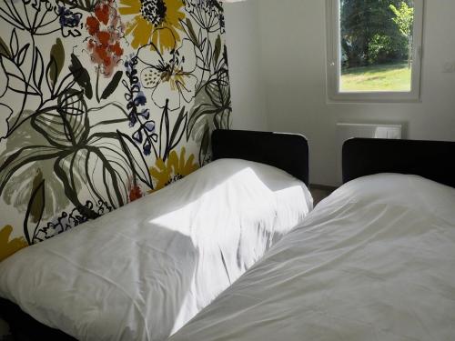 - une chambre avec un lit et un mur fleuri dans l'établissement Appart T4 neuf à 5 min du centre, à Le Touquet-Paris-Plage