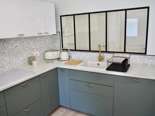 une cuisine avec des armoires bleues et un évier dans l'établissement Appart T4 neuf à 5 min du centre, à Le Touquet-Paris-Plage