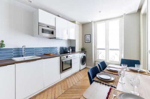 une cuisine et une salle à manger avec une table et des chaises dans l'établissement COSY APPARTMENT IN THE HEART OF PARIS, à Paris