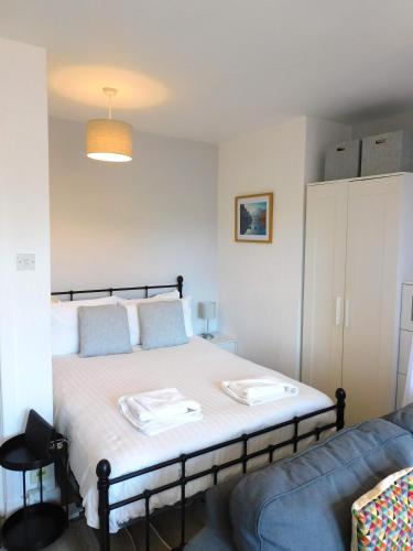 a bedroom with a bed and a blue couch at Modern bright studio apartment in south Glasgow in Glasgow