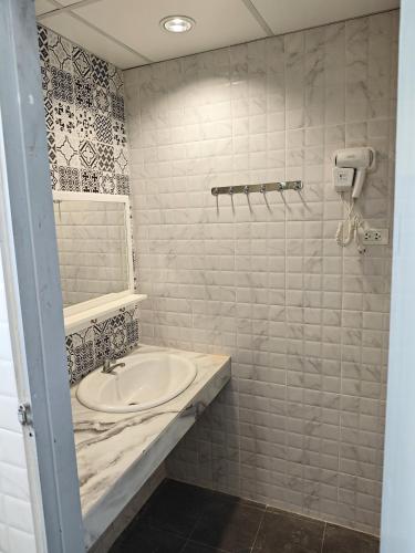a bathroom with a sink and a shower at latitude 13 Room & breakfast in Bangkok