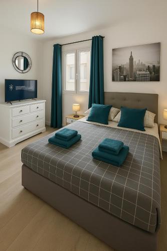 une chambre avec un grand lit avec des oreillers bleus dans l'établissement Appartement T4 95m2 Plage pointe rouge 10 min stade Velodrome, à Marseille