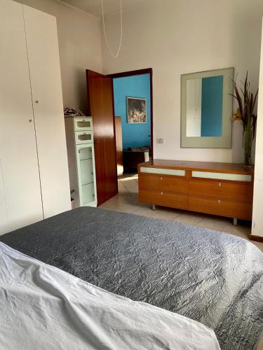 a bedroom with a bed and a dresser and a mirror at Appartamento 550 mt dal mare in Punta Marina