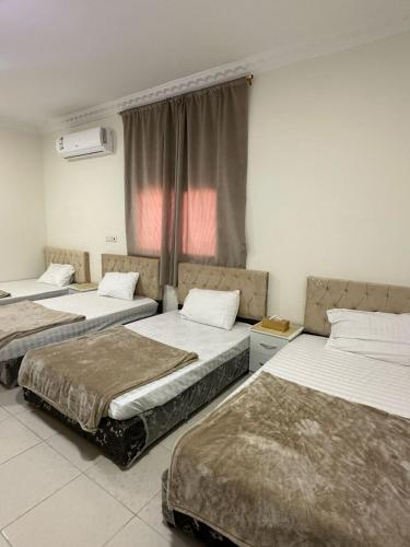 a room with three beds and a window at مساكن المدينة المنورة in Medina