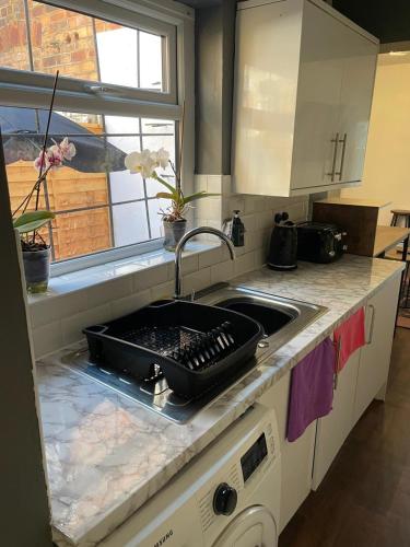 a kitchen counter with a sink with a pan on it at Cosy home in the City Centre in Wolverhampton