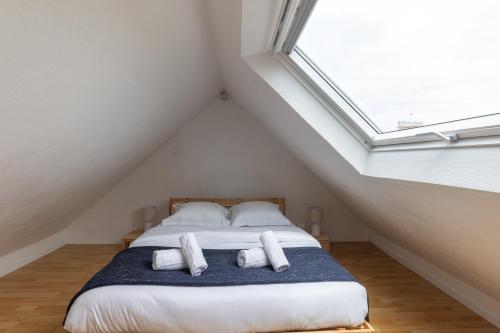 une chambre avec un lit avec deux oreillers dessus dans l'établissement Le Petit Schilik - Proche de Strasbourg, à Schiltigheim