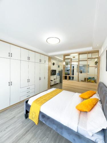 ein Schlafzimmer mit einem großen Bett mit gelben Kissen in der Unterkunft Kev Staycations in Nairobi