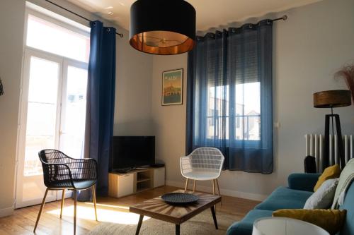 un salon avec un canapé bleu et des chaises dans l'établissement Au Petit Pelloutier, à Albi