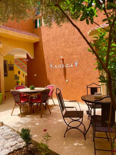 a patio with a table and chairs and a building at Dyafat Abla in Ouarzazate