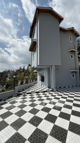 a building with a checkered floor on a balcony at दोgri Homes in Kīar