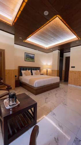 a large bedroom with a bed and a table at दोgri Homes in Kīar