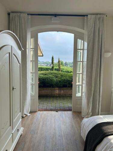 a bedroom with a door open to a garden at Monferrato Country House Basin dAmor Casa di campagna in Asti