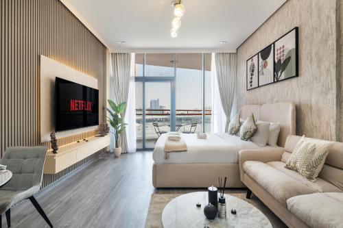 a living room with a bed and a tv at Trendy Studio Apartment in Binghatti Crystals in Dubai
