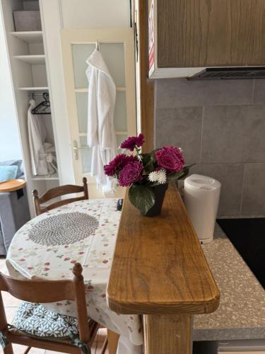 une table avec un vase de fleurs dessus dans l'établissement Rennes-les-Bains Studio at foot of thermal baths, à Rennes-les-Bains