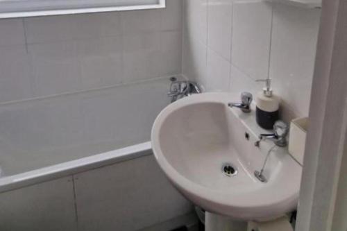 a white bathroom with a sink and a tub at Gillingham Home - Sleeps 4 - Comfort & Convenience in Gillingham