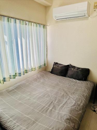 a bed in a room with a window at JOJO TC house in Osaka