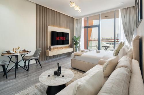 a living room with a couch and a bed and a tv at Trendy Studio Apartment in Binghatti Crystals in Dubai