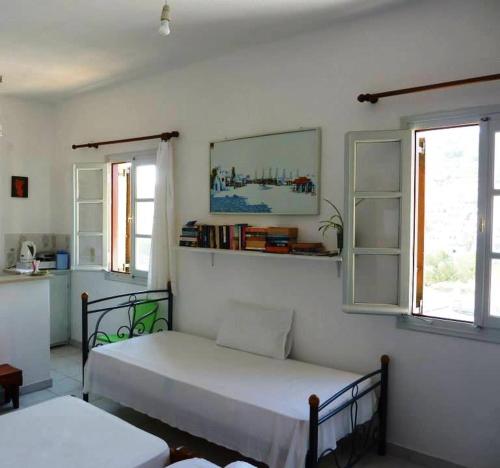 um quarto com uma cama e duas janelas em Marietta Studios Patmos em Skala