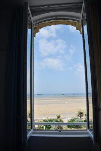 an open window with a view of the beach at Les Tourelles Village de vacances in Asnelles