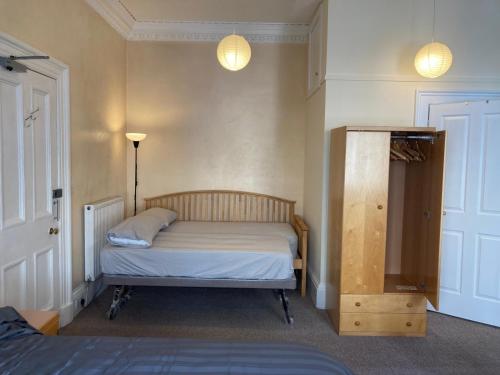 1 dormitorio pequeño con 1 cama y 2 luces en Gilmore Flat, en Edimburgo