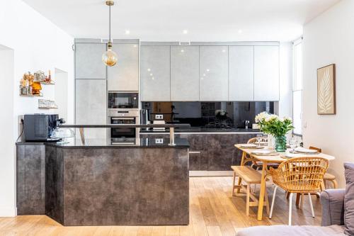 Il comprend une cuisine et une salle à manger avec une table. dans l'établissement GuestReady - Elegant retreat near the Eiffel Tower, à Paris