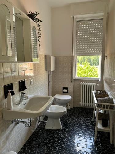 a bathroom with a sink and a toilet and a window at Vesta in Gargnano