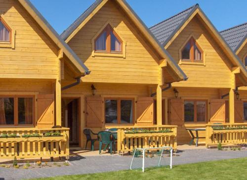 a wooden house with a picnic table in front of it at Dobre Smaki Apartaments Chill and Food in Sarbinowo