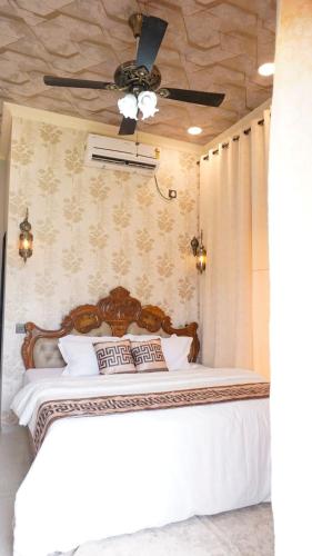 a bedroom with a bed with a ceiling fan at AG Villa in Neral