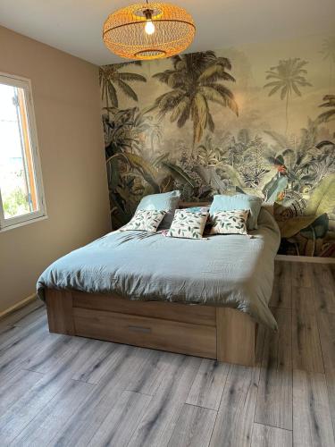 une chambre avec un lit avec un tableau sur le mur dans l'établissement Jolie maison les pins et la mer pour 4 personnes, à Marennes