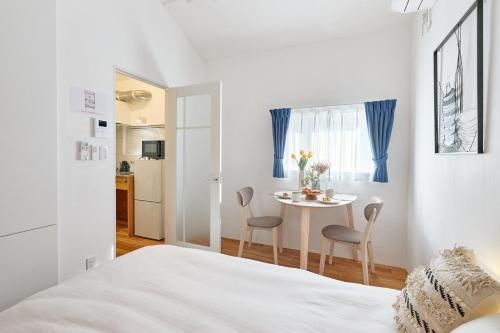 a bedroom with a bed and a table with chairs at Spacious House for 2people 7min Ohanajaya Sta 14min Skytree 19min Asakusa 20min Ueno Comfortable Stay Tokyo HANACHO お花茶屋 ゆったり2名 Gato Ohanajaya in Tokyo