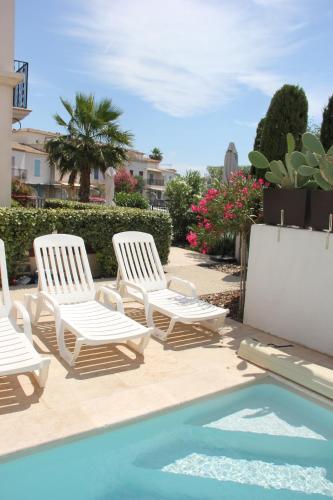 - un groupe de chaises longues et une piscine dans l'établissement La Batelière, entre mer, Camargue et Canaux, à Aigues-Mortes