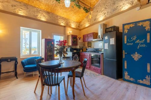 une cuisine avec une table, des chaises et un réfrigérateur dans l'établissement Logement féerique SPA & terrasse - proche Pézenas, à Abeilhan