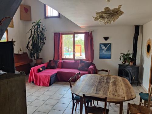 un salon avec un canapé violet et une table dans l'établissement Soleil bleu, à Rognes