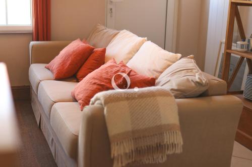 un canapé avec des coussins dessus dans un salon dans l'établissement COC - Villa Chantoiseau, à Wissant