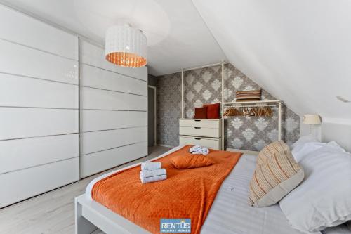 una camera da letto con un letto con una coperta arancione di Groenhage - enjoy peace in the heart of Leffinge a Middelkerke