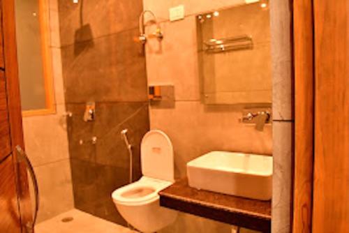 a bathroom with a toilet and a sink and a shower at Hotel Mountain Majesty's Inn, Manāli in Manāli