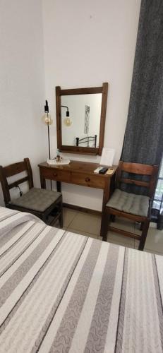 a bedroom with a desk and a bed and a mirror at Liogerma in Adamas