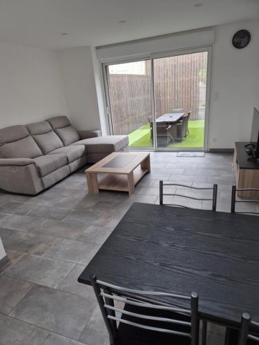 una sala de estar con un sofá y una mesa en Gite de l'usine, en Roussay