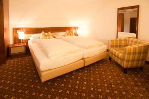 a bedroom with a large bed and a chair at Zum Dorfschmied in Klein Sankt Paul