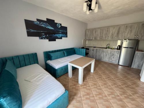 a room with a couch and a table and a kitchen at Full Moon Apartments in Ksamil