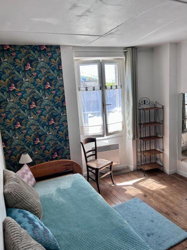 - une chambre avec un lit bleu et un mur orné de fleurs dans l'établissement L'Escaleyrou, gîte familial, charme & confort pour un séjour à côté de Lascaux, à Aubas