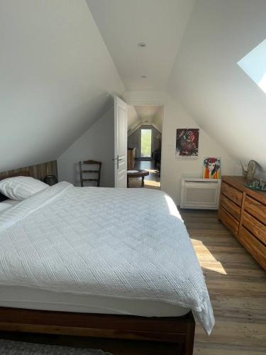 une chambre avec un grand lit et un escalier dans l'établissement Le repaire des trois singes, à Brésilley