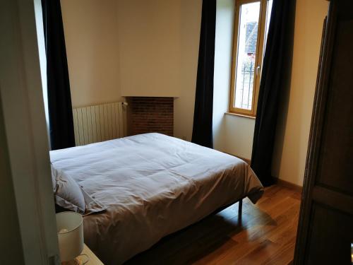 a bedroom with a bed in a room with a window at La Maison d'Hortense au coeur du vignoble in Saint-Bris-le-Vineux