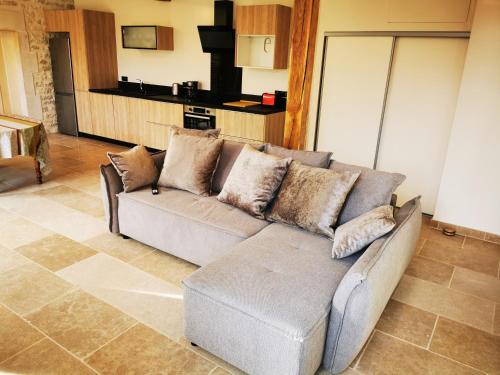 a living room with a couch and a kitchen at La Maison d'Hortense au coeur du vignoble in Saint-Bris-le-Vineux