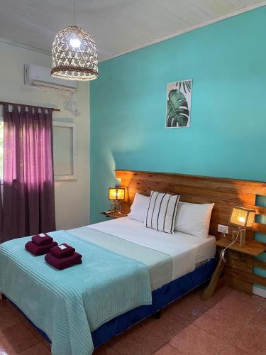 a bedroom with a large bed with a blue wall at Hotel Puerto Libertad - Iguazú in Puerto Libertad